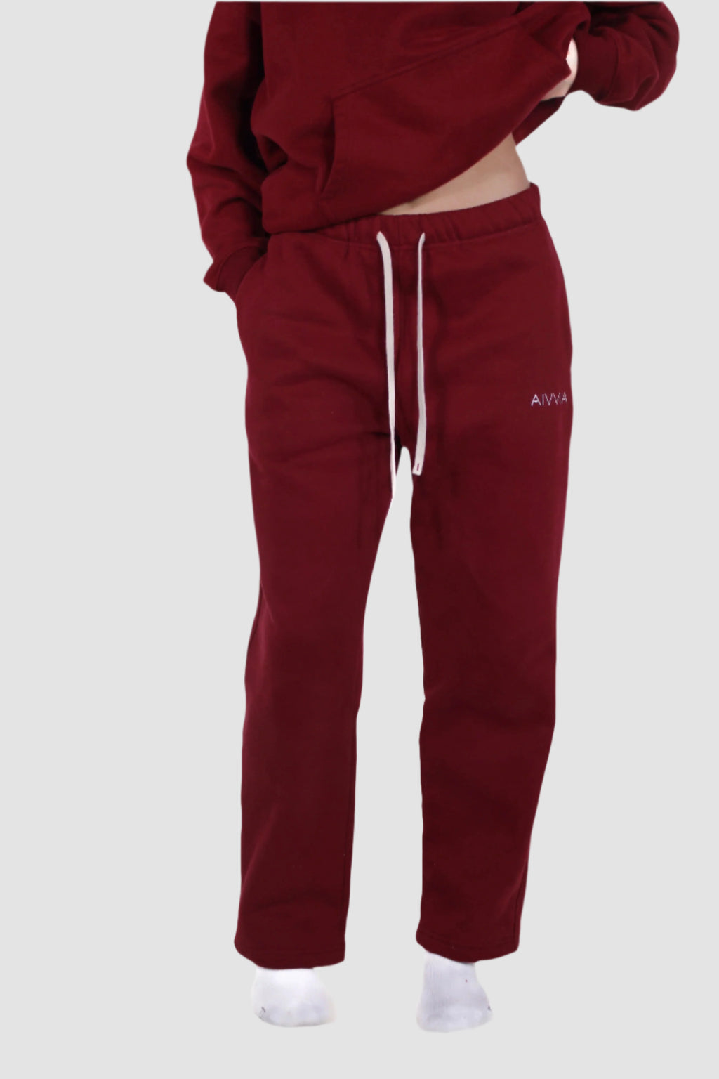 Deep red Aivvia Athletics sweatpants styled for both rest and motion; warm-toned fleece and functional fit.