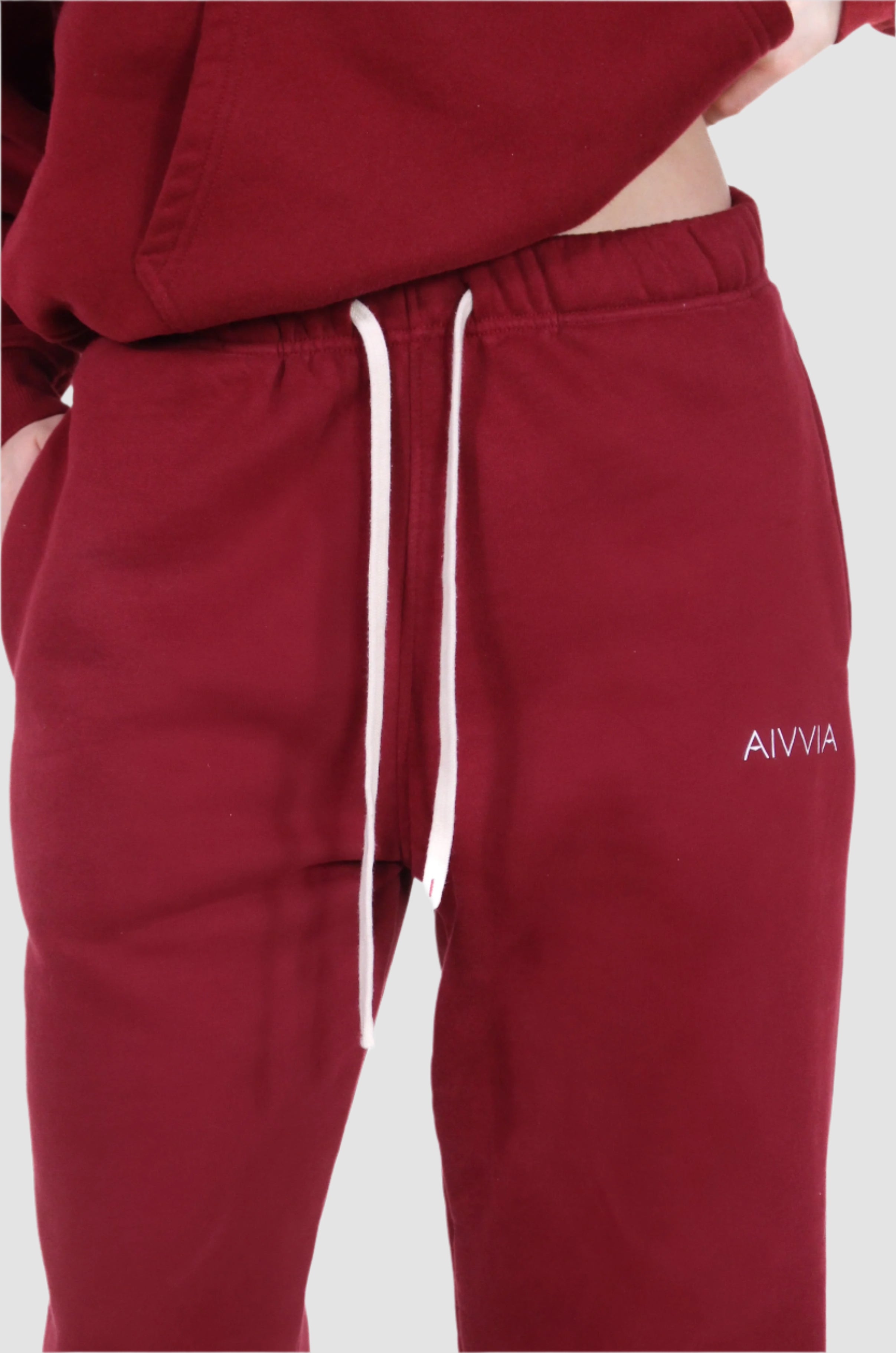 Close-up of Aivvia Athletics burgundy sweatpants, adjustable drawstring, soft athletic loungewear for women.