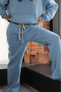 Light blue Aivvia Athletics sweatpants with drawstring waist, relaxed fit, and soft fleece; cozy and confident pose.