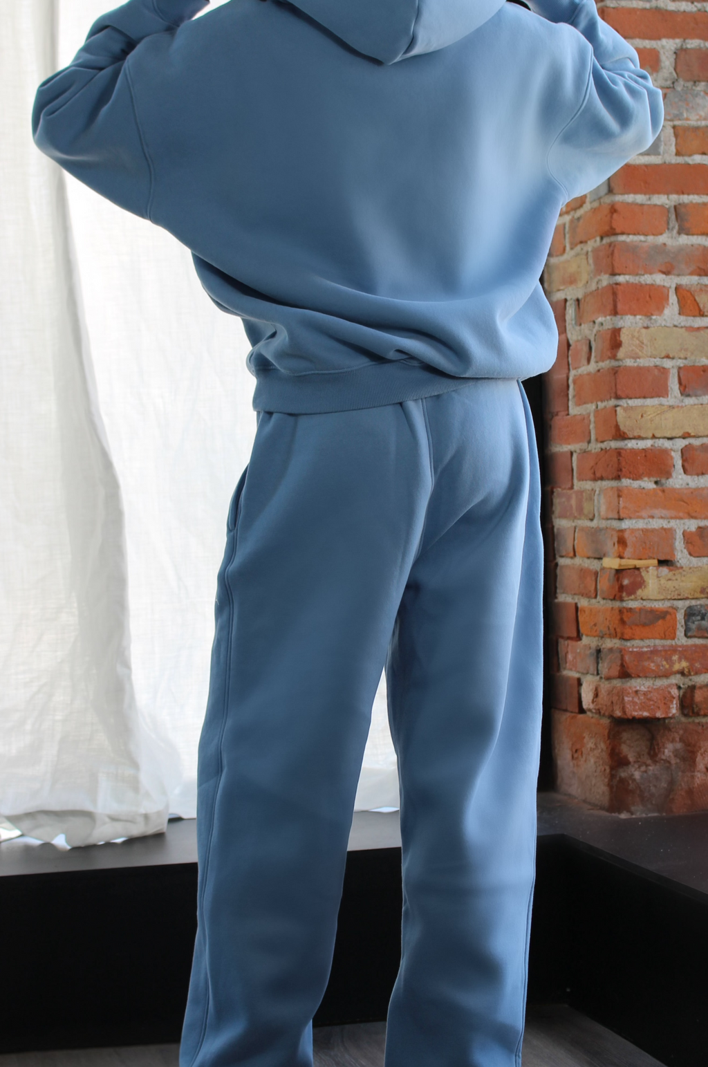 Side view of Aivvia Athletics blue fleece sweatpants featuring tapered legs and high-rise fit for elevated athleisure.