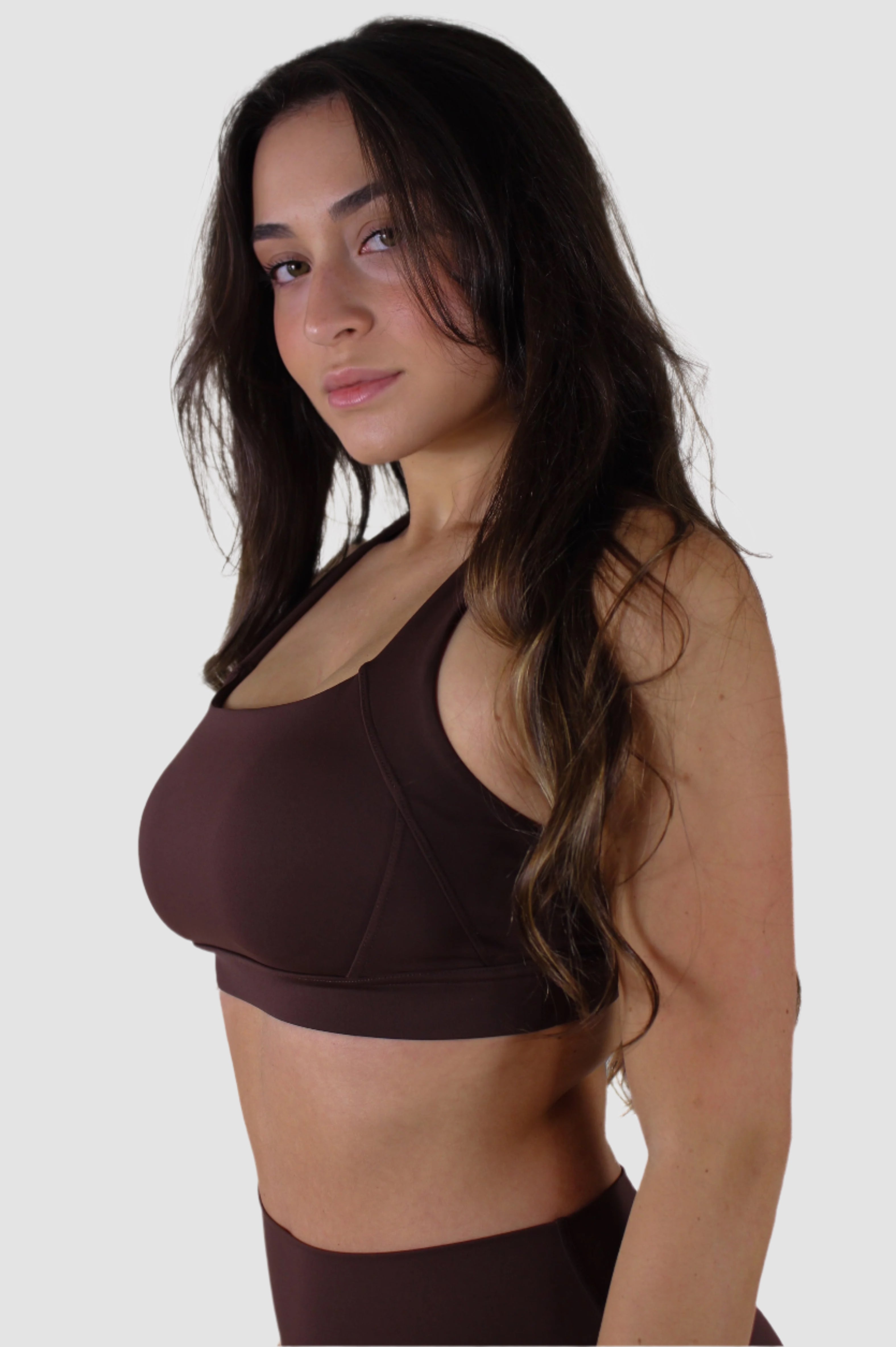 Angled front view of brown Aivvia Athletics sports bra with wide straps and smooth finish.