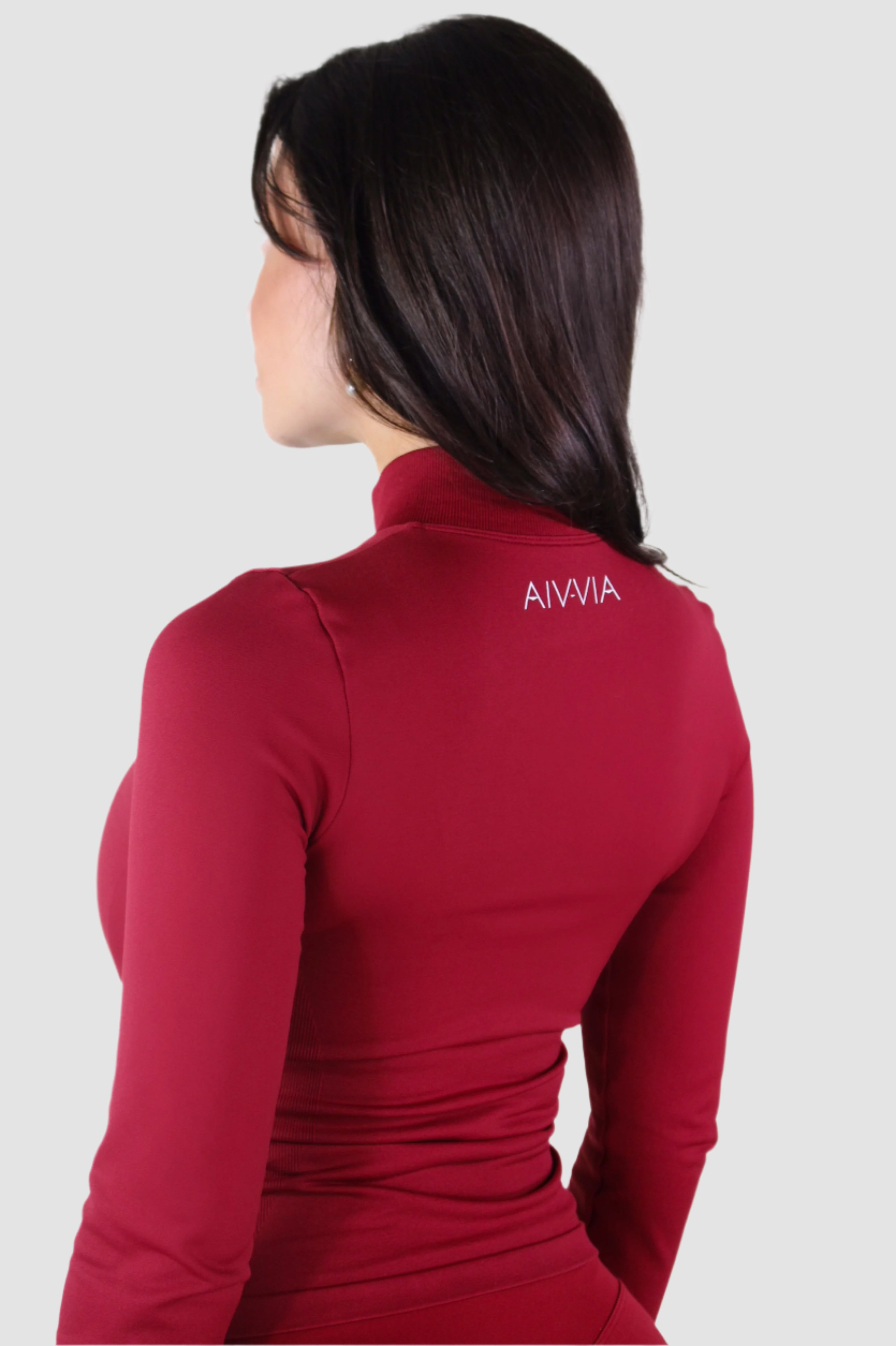 Side-angled back view of red Aivvia Athletics women’s jacket, breathable and versatile sportswear layer.