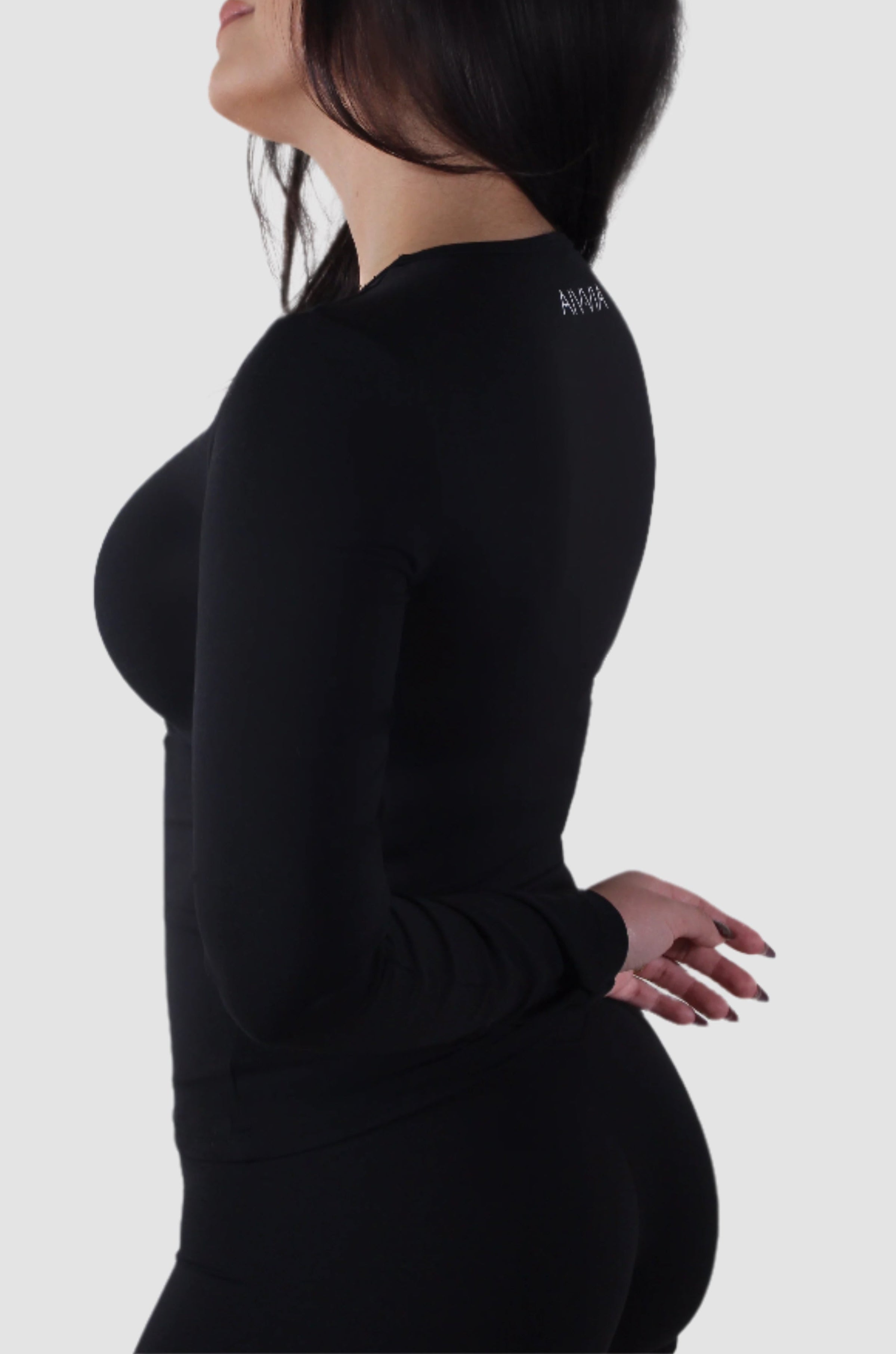 Side profile of Aivvia Athletics Tone Long Sleeve in black — sleek, sculpting workout shirt for women with seamless, curve-enhancing fit.