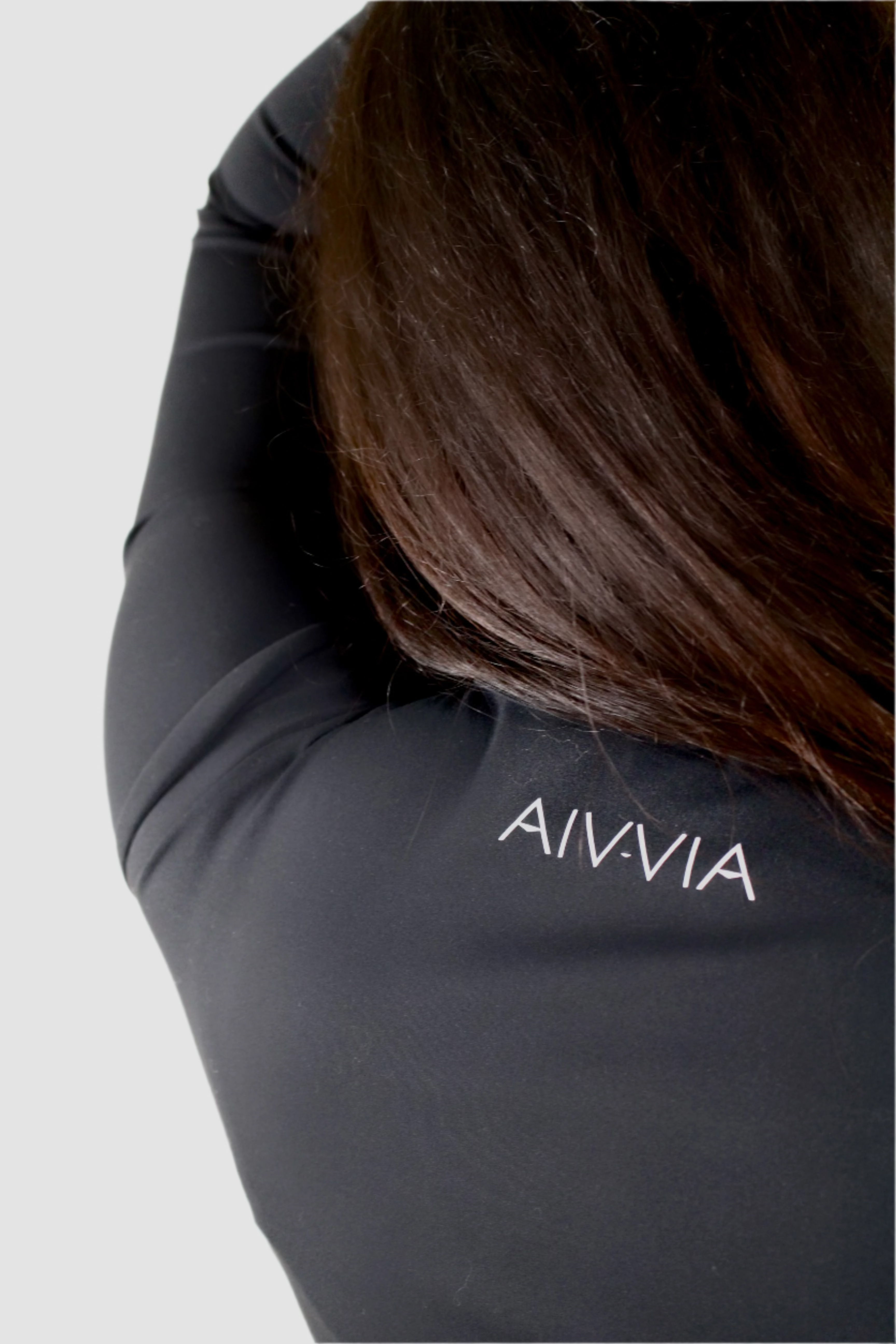 Close-up of Aivvia Athletics logo on the back of Tone Long Sleeve in black — minimalist branding on premium seamless women’s activewear.